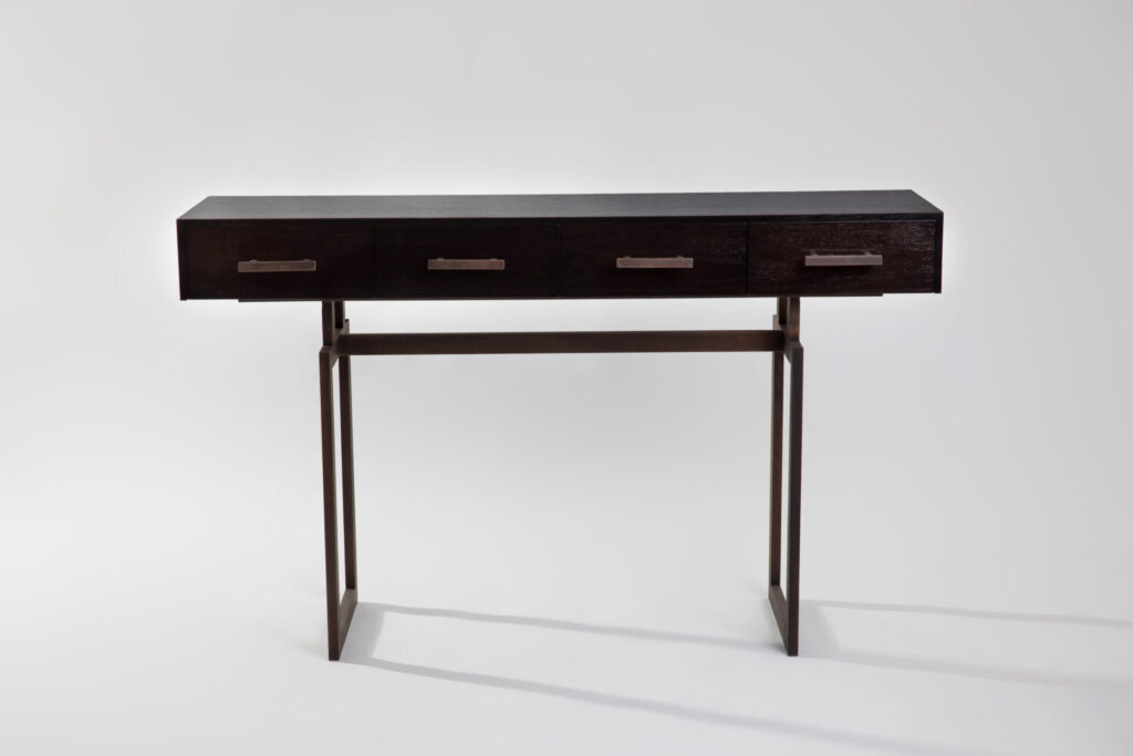 Dark wood desk with four drawers and a slim metal frame, set against a light gray background.