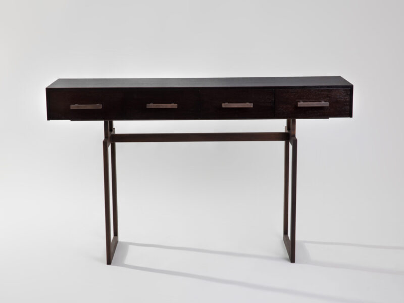 Dark wood desk with four drawers and a slim metal frame, set against a light gray background.